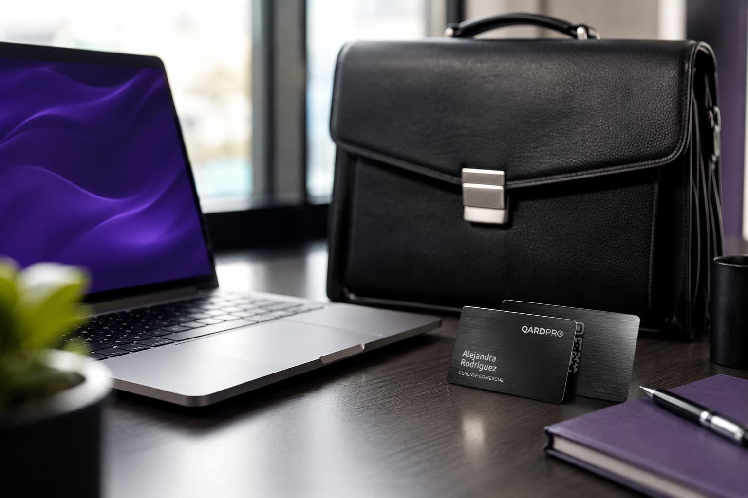 Tarjetas QARDPRO metálicas sobre un escritorio ejecutivo junto a un maletín de cuero